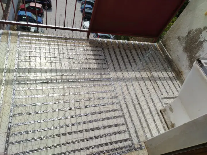 Balcone protetto con rete di dissuasori dopo l'intervento